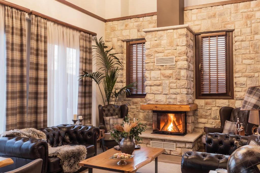 a living room with leather furniture and a fireplace at MONTANA LAKE VIEW in Ioannina