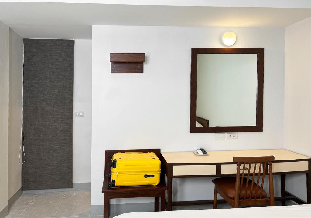a room with a table with a yellow bag on it at Niagara Hotel in Bangkok