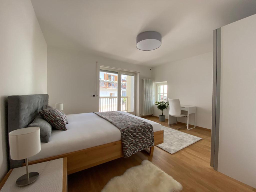 a white bedroom with a bed and a desk at Sonnhof in Trodena