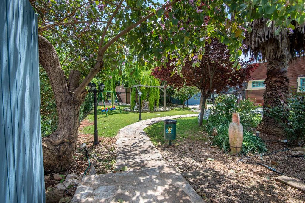 a garden with a tree and a path at SOL Suite In The Village in Shomera