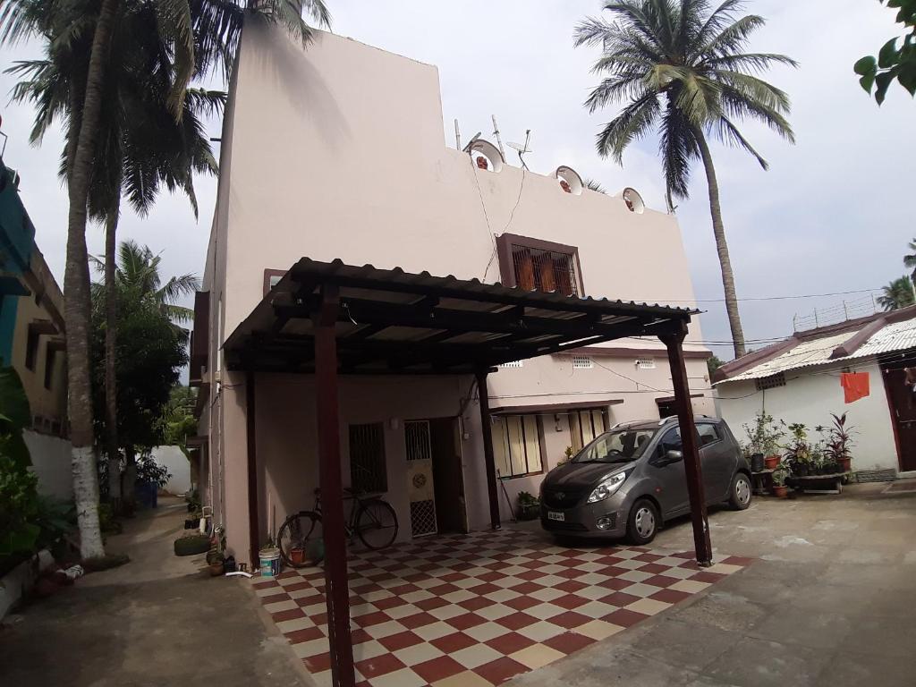 um pequeno carro estacionado em frente a um edifício em Sudha Kutir Puri em Puri