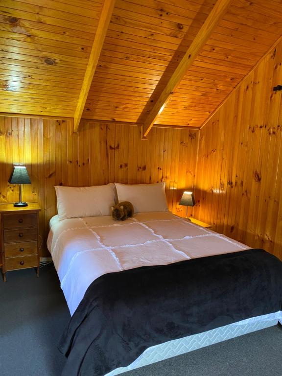 sypialnia z dużym łóżkiem w drewnianym suficie w obiekcie The Wombat Cottage w mieście Tullah