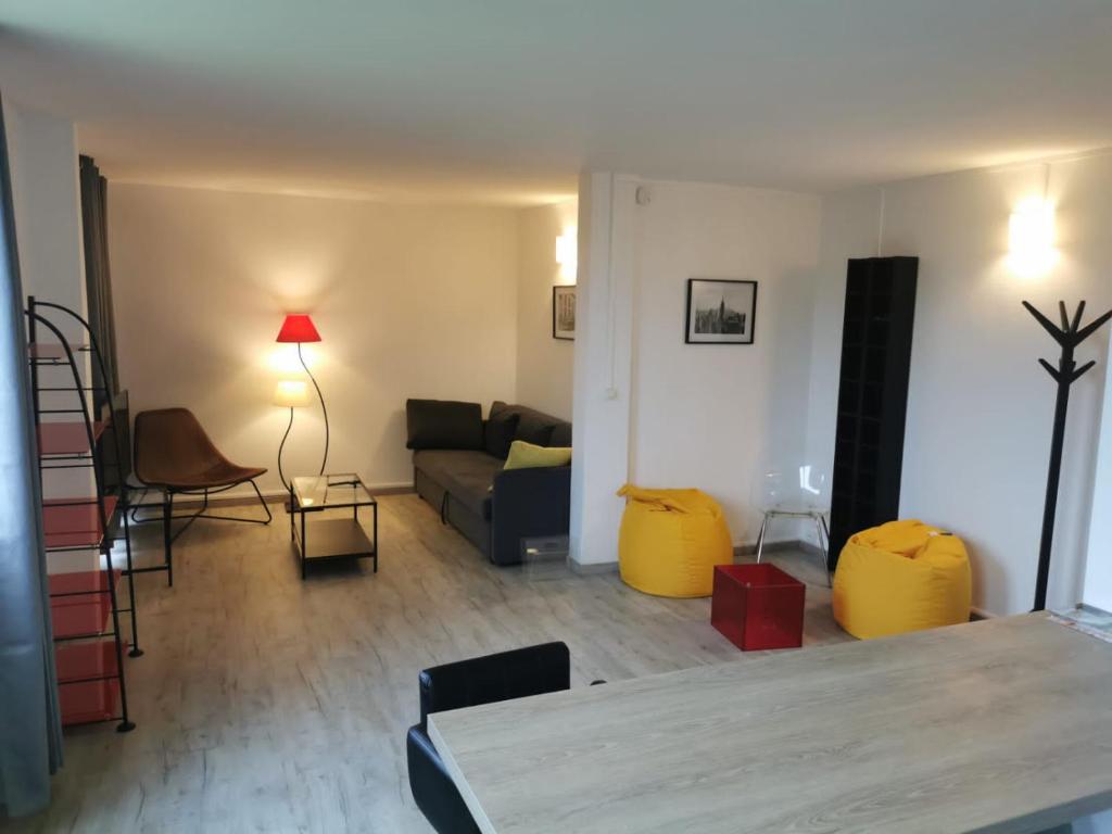 ein Wohnzimmer mit einem Sofa und einem Tisch in der Unterkunft Au Saint-Hubert, Appartement 3 chambres Valenton in Valenton