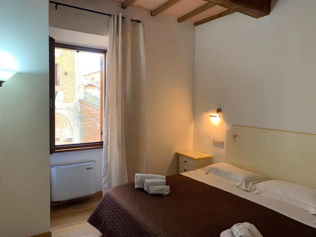 a small bedroom with a bed and a window at Residenza Via Dante in Gubbio