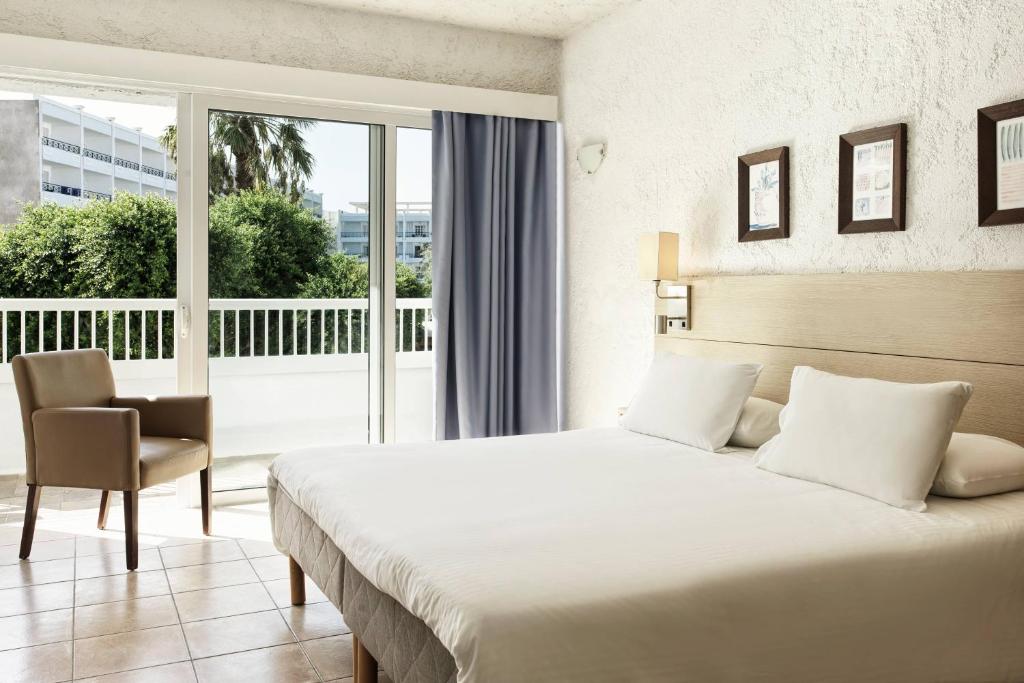 a hotel room with a bed and a balcony at The Apartments by Esperia in Rhodes Town