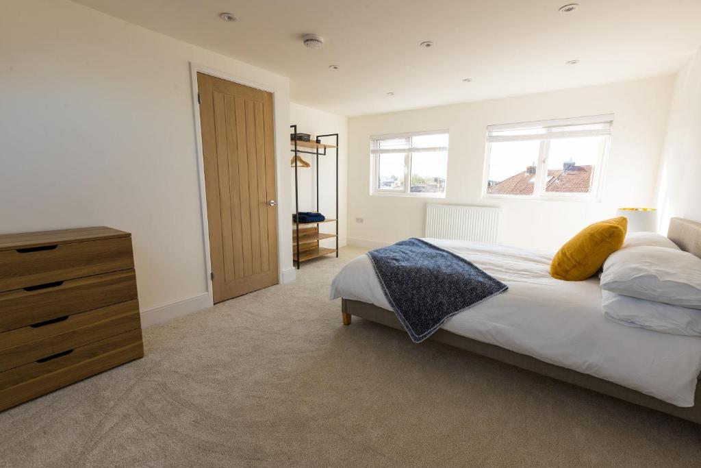 a bedroom with a bed and a wooden dresser at Amazing new 3 double bed house in staple hill! in Bristol