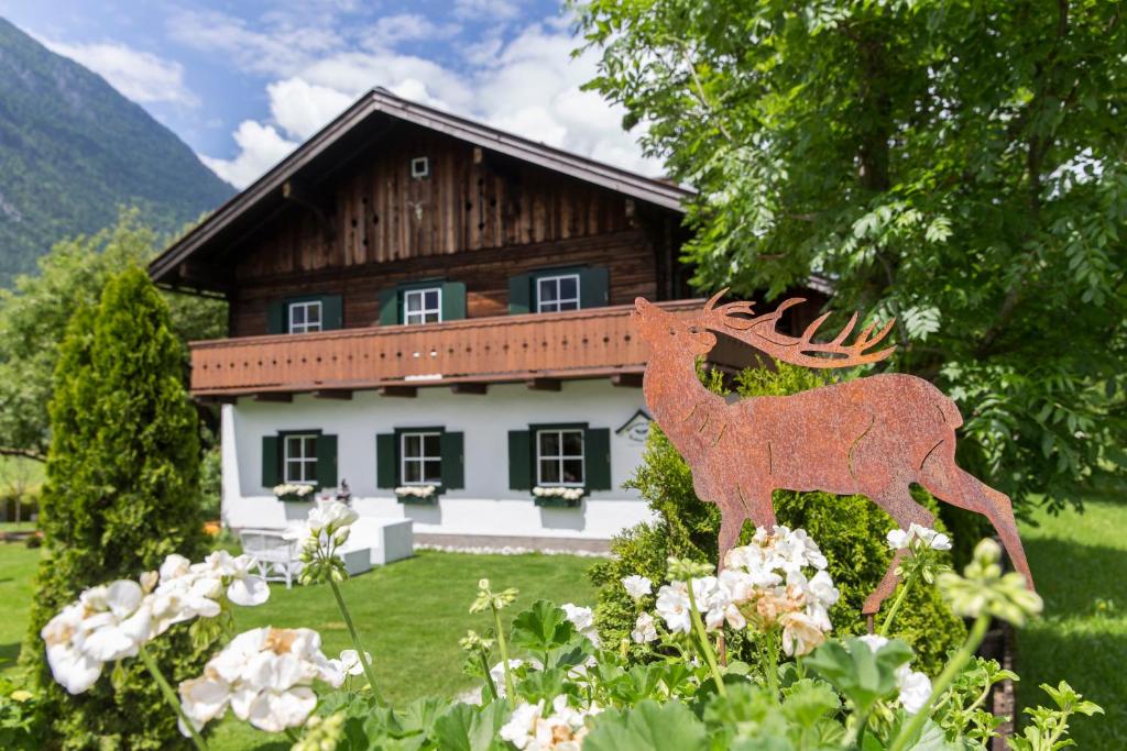 eine Hirschstatue vor einem Haus in der Unterkunft Forest Chalet, secluded location, 1,000 sqm garden, mountainview, panorama sauna, whirlpool, BBQ&bikes&sunbeds for free, up to 10 p in Golling an der Salzach