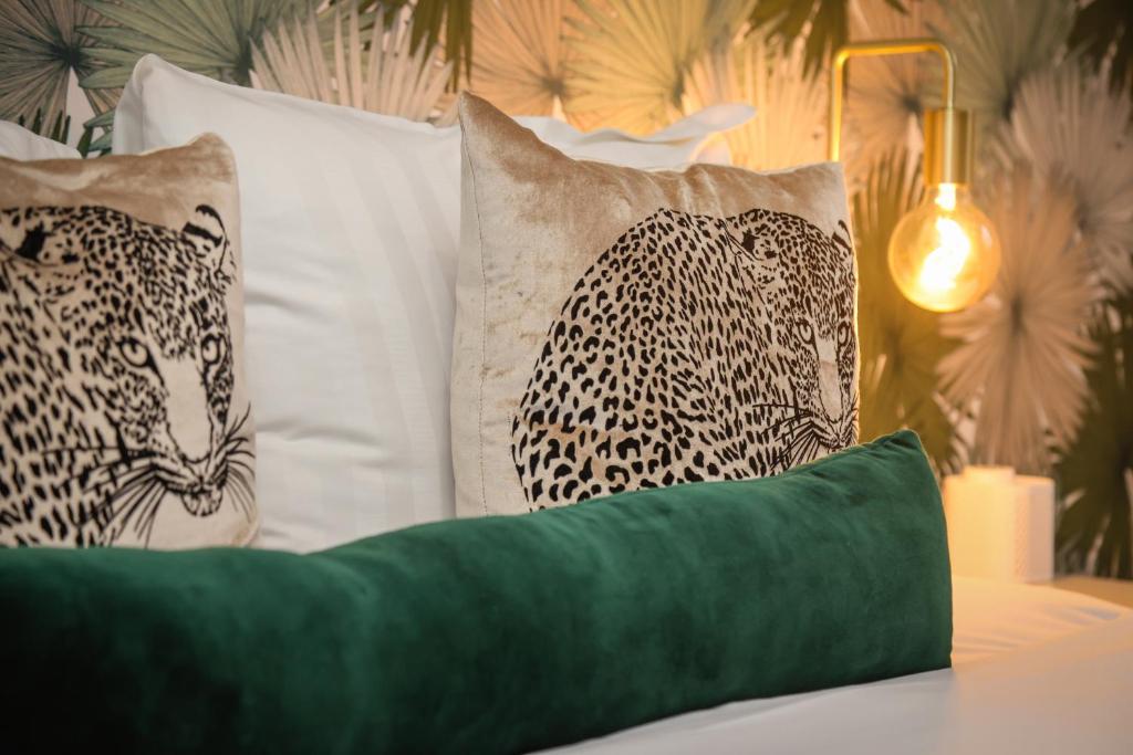 a bed with two leopard pillows and a green pillow at The Ashleigh - Dog Friendly in Bournemouth