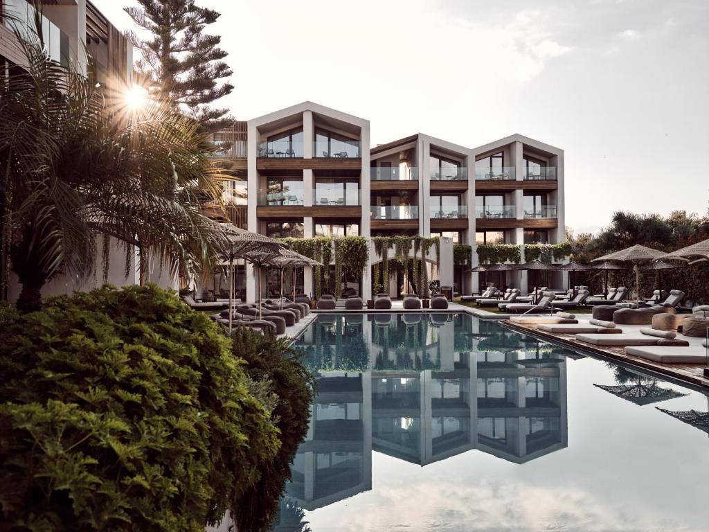 un hotel con piscina con sillas y un edificio en Contessina Hotel, en Tsilivi