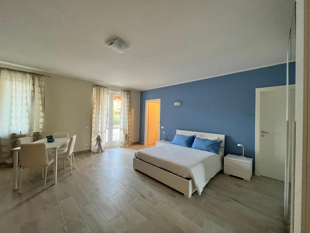 1 dormitorio con cama, mesa y pared azul en Casa Cost 2, en Vetralla