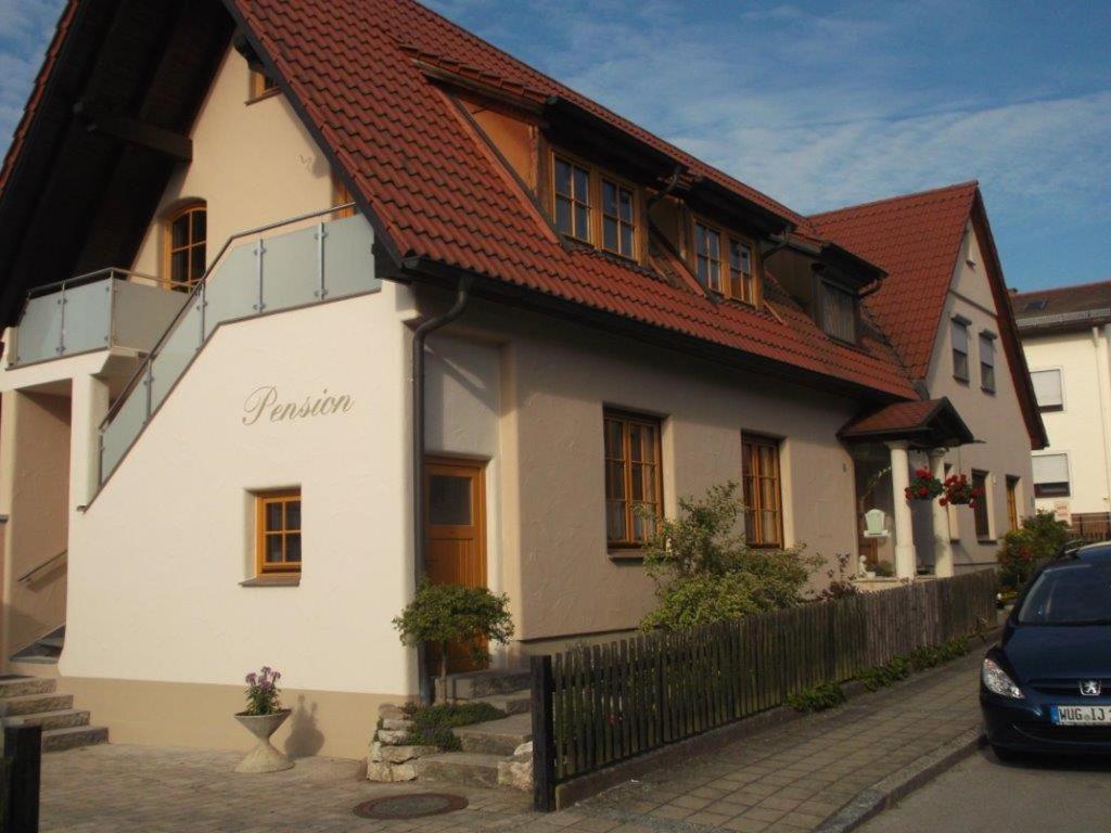 um edifício branco com um telhado vermelho em Pension/FeWo E. Tschernach em Treuchtlingen