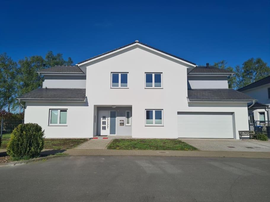 a white house with a driveway in front of it at Ostsee-Luxus-Ferienwohnung Sanitz in Sanitz