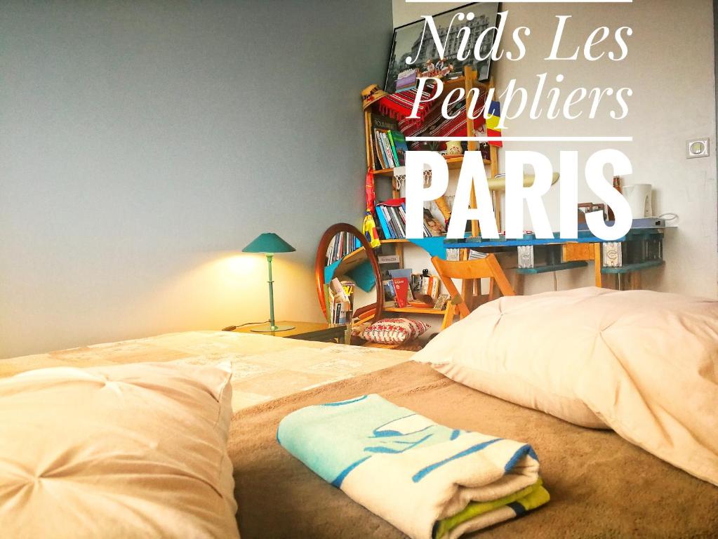 a bed with two pillows and a sign that reads kids las paviliers at Nids Les Peupliers Paris in Longjumeau