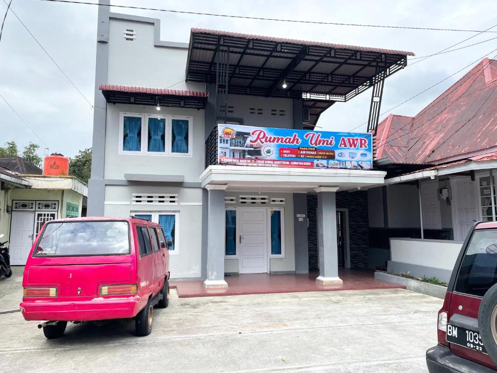 a red van parked in front of a building at Rumah Umi AWR in Bukittinggi