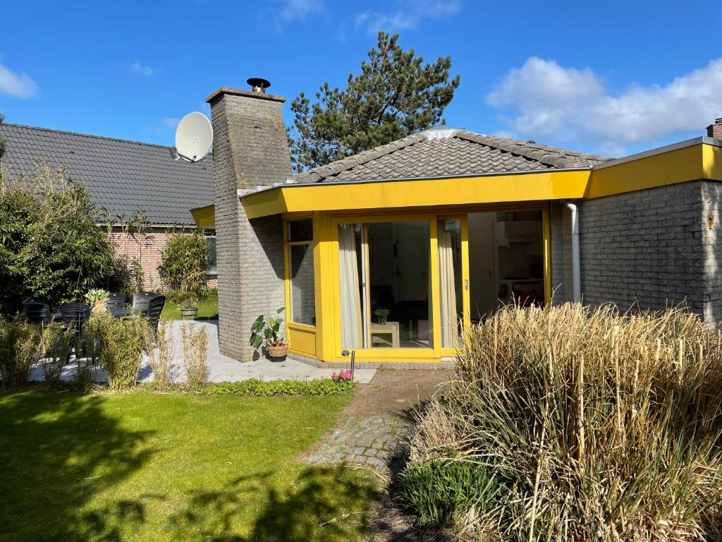 ein Haus mit gelber Eingangstür in der Unterkunft Zeester 5 personen * in Julianadorp