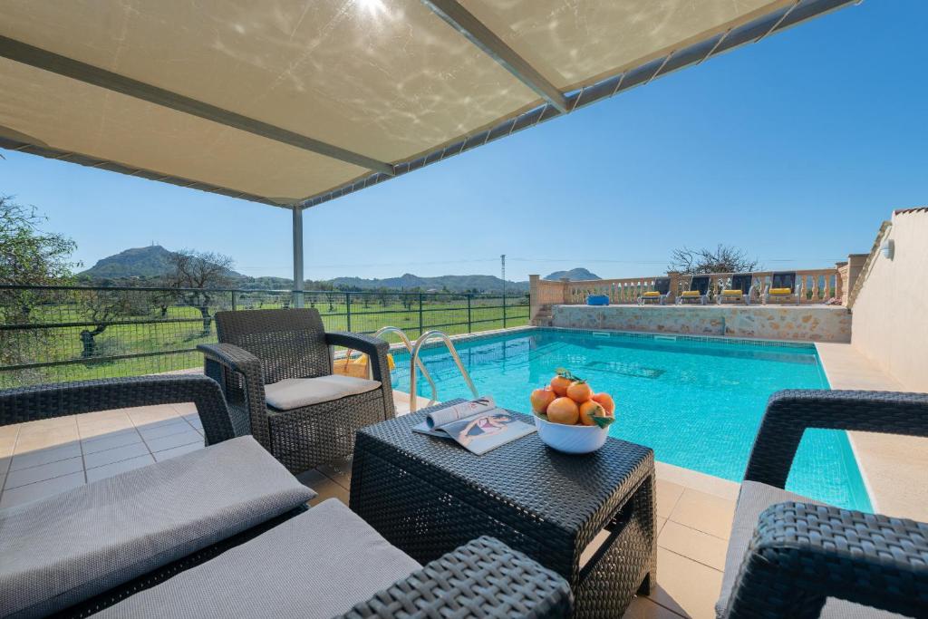 een terras met een tafel en stoelen en een zwembad bij Sunset Finca Can Gosp in Alcudia