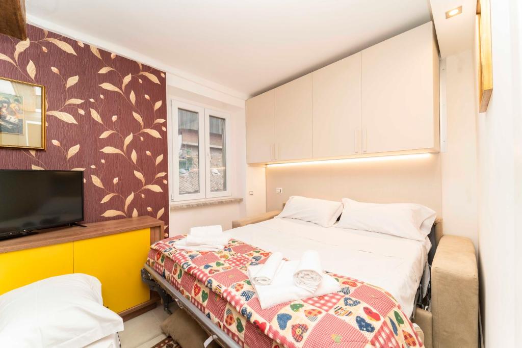 a small bedroom with a bed and a tv at Castello Central & Panoramic Studio in Turin