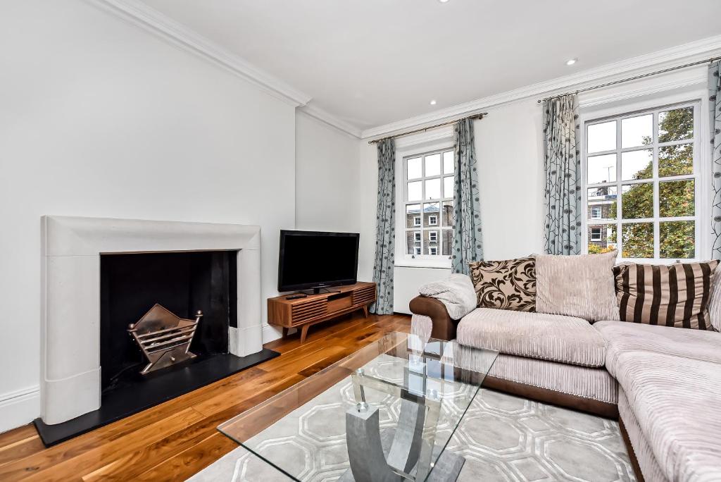 a living room with a couch and a fireplace at Marylebone Apartment in London