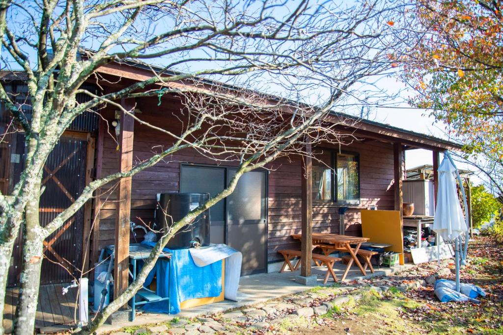 Casa pequeña con porche y mesa en Soil, en Minami Aso