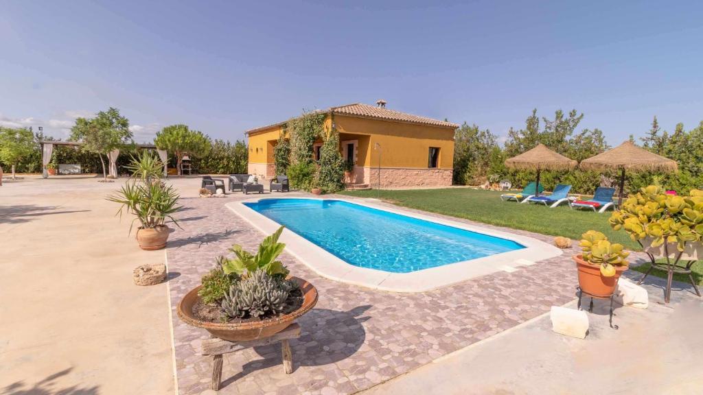 - une piscine dans une cour avec une maison dans l'établissement Casa Rural Villa Lucrecia, à La Lantejuela