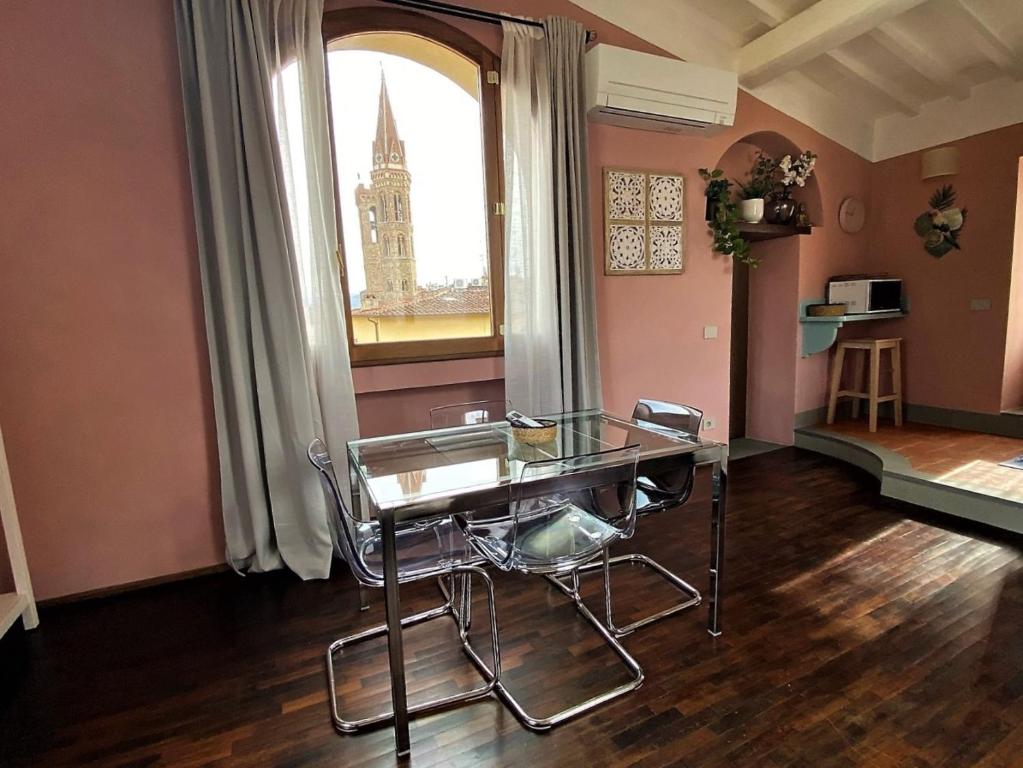 jadalnia ze szklanym stołem i oknem w obiekcie Romantico nido nel cuore di Firenze we Florencji