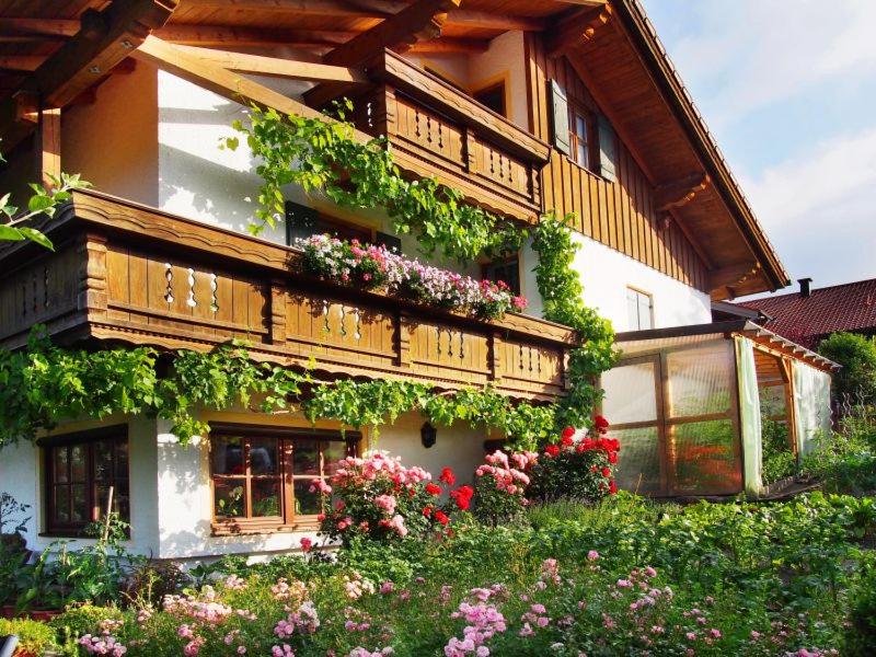 ein Gebäude mit vielen Pflanzen und Blumen darauf in der Unterkunft Ferienwohnung Gruber in Teisendorf