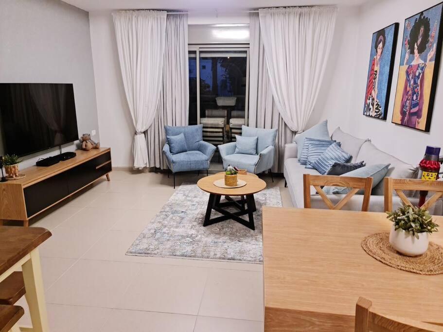a living room with a couch and a tv at מרחק נגיעה בתקווה in Petaẖ Tiqwa