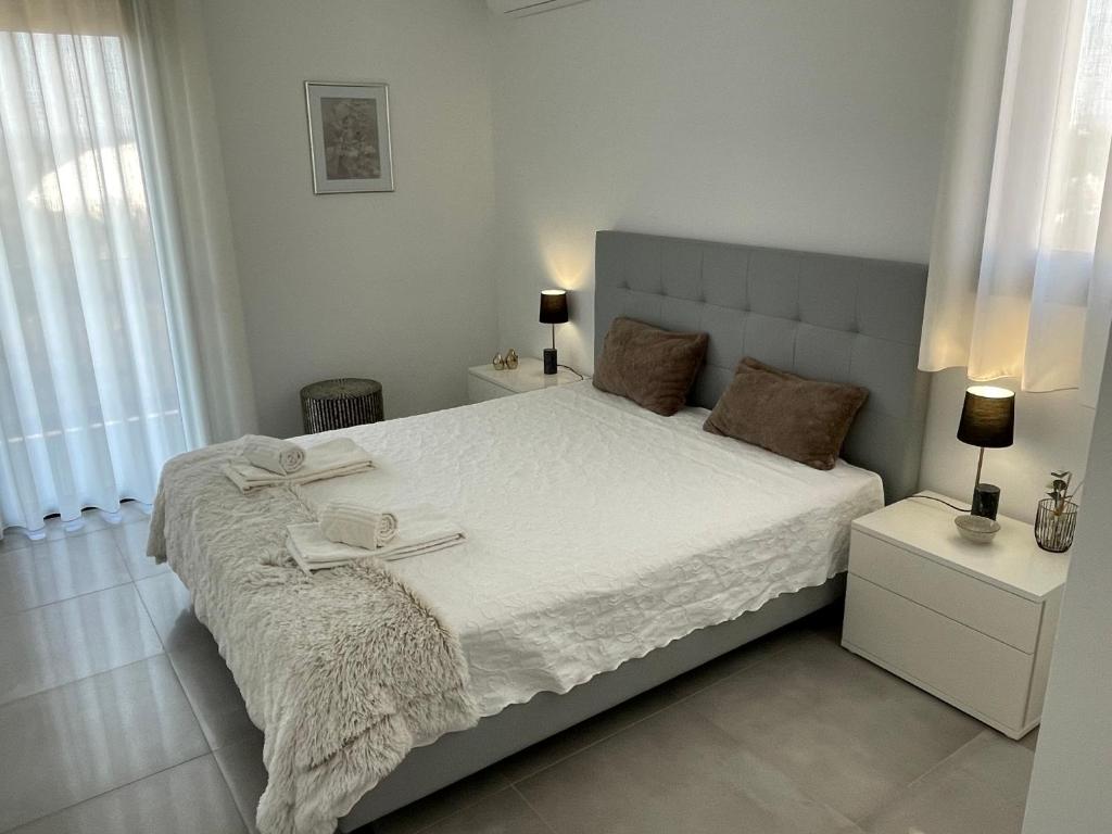 a white bedroom with a large bed with white sheets at Salinas House T3 in Tavira