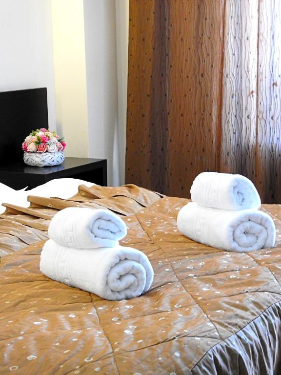 a bed with towels on top of it with a pile thereof at Pensiunea Eric in Iaşi