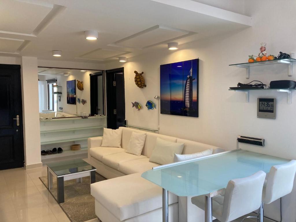 een woonkamer met een bank en een glazen tafel bij Diar El Rabwa Modern Apartment with Free WiFi and Private Balcony in Sharm El Sheikh