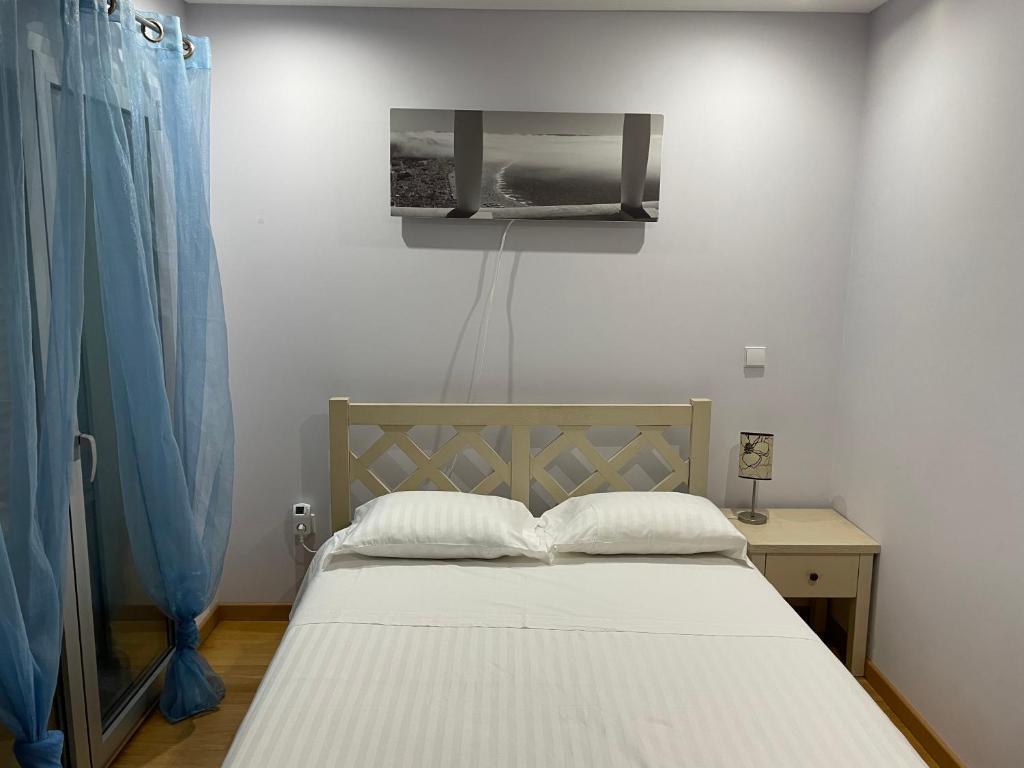 sypialnia z łóżkiem i telewizorem na ścianie w obiekcie Bed & Seaside w mieście Nazaré