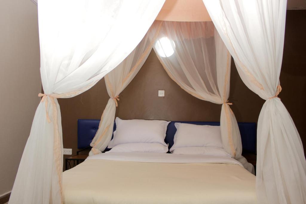a bedroom with a bed with curtains above it at Sweet Lake Resort in Naivasha