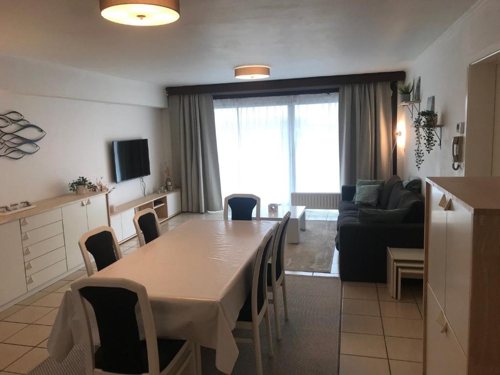 cocina y sala de estar con mesa y sillas en Gezinsappartement - La Plage - Wenduine zeedijk, en Wenduine