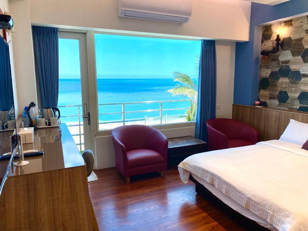 um quarto de hotel com uma cama e vista para o oceano em 36 Lighthouse em Hualien City