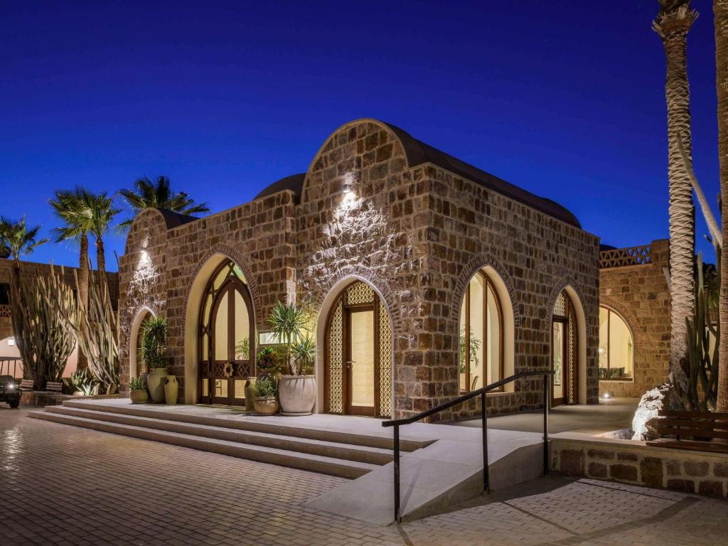 um edifício de tijolos com palmeiras em frente em Movenpick Resort El Quseir em El Quseir