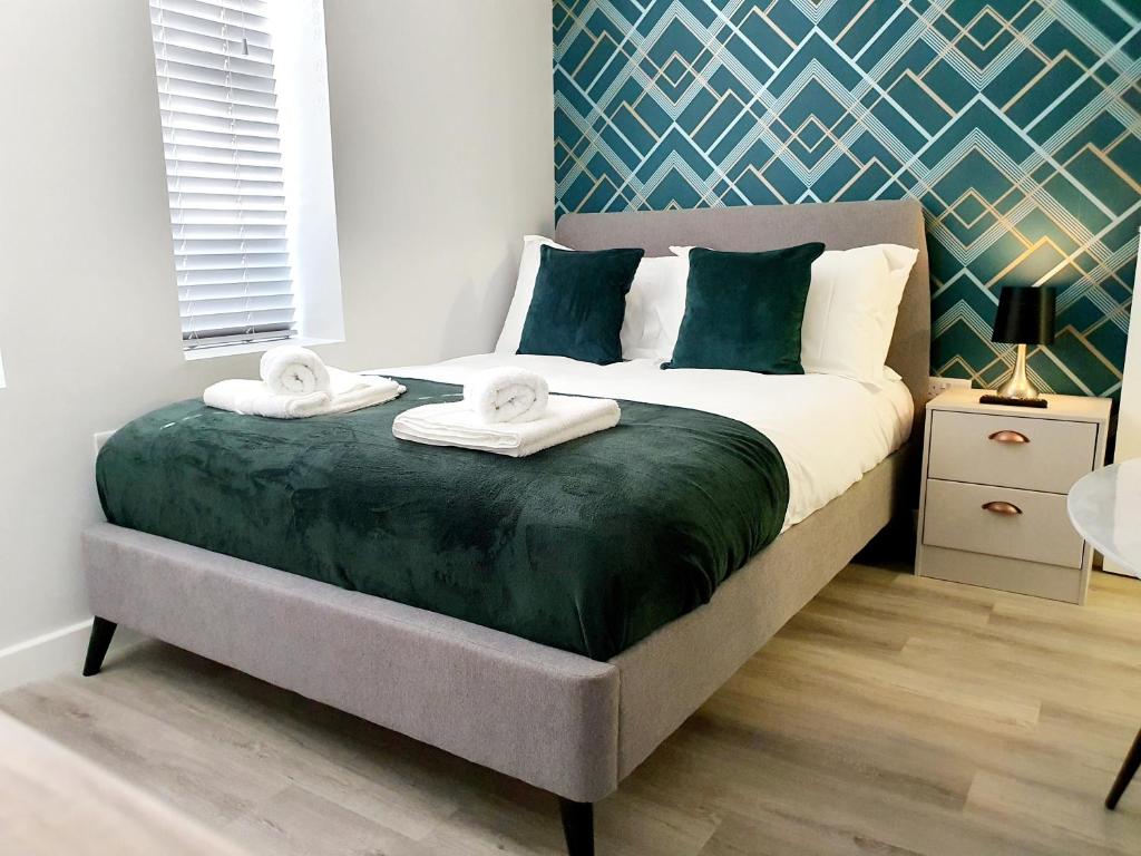 um quarto com uma cama grande e toalhas em Modern Town Centre Studio Close to Beach em Bournemouth