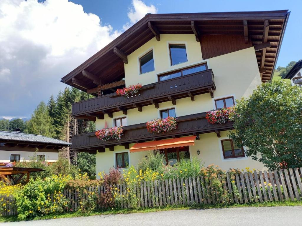 ein Haus mit Blumenkästen an der Seite in der Unterkunft Appartements Lederer in Maria Alm am Steinernen Meer