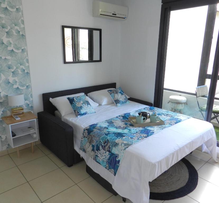 a bedroom with a bed with a tray on it at Le Lobellia à Sainte Clotilde centre in Sainte-Clotilde