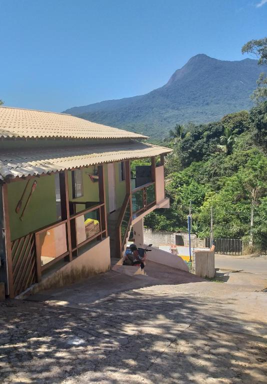 a building with a staircase and a mountain in the background at Casa do Mar & Ane Ilhabela in Ilhabela