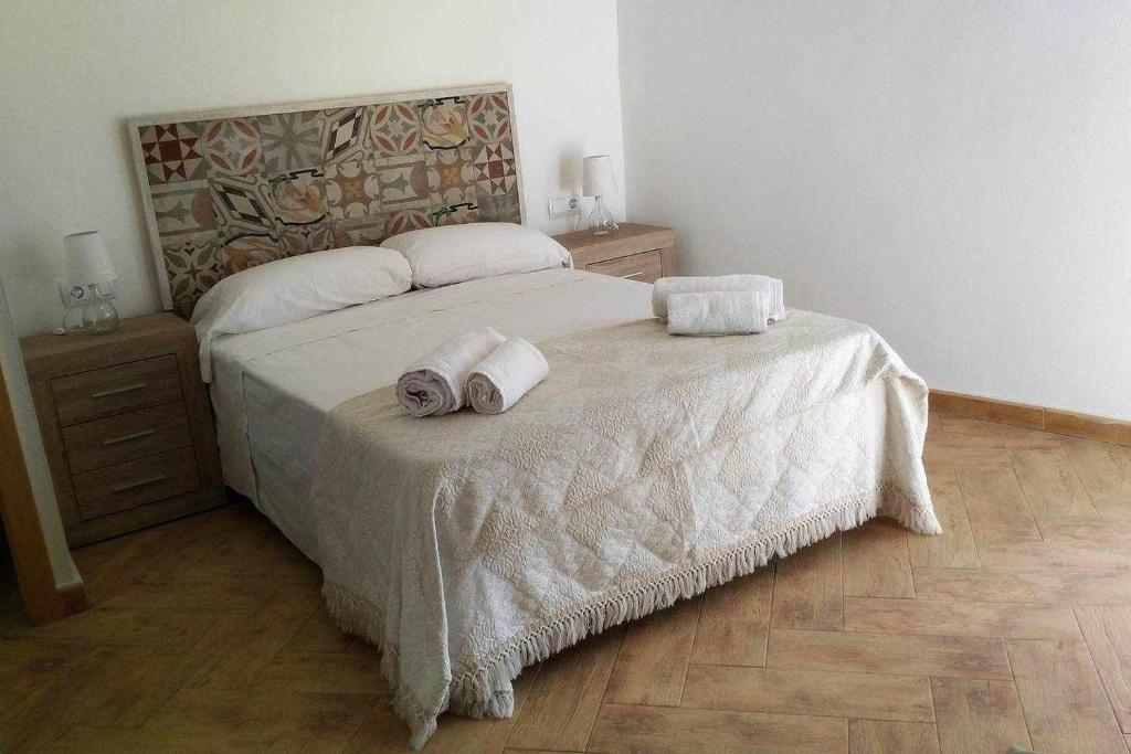 a bedroom with a bed with two towels on it at Casa de pueblo con encanto in Tarragona