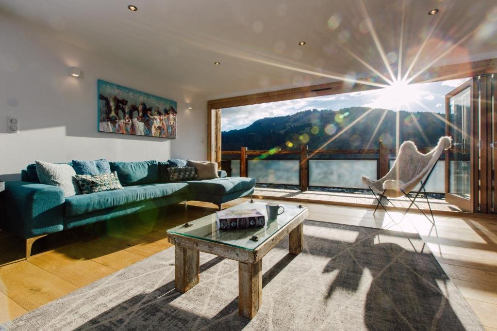 a living room with a blue couch and a table at Chalet Lumina in Morzine