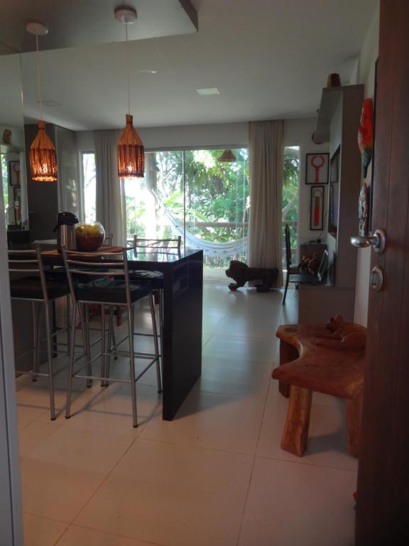 a kitchen and dining room with a table and chairs at Bangalô no alto da colina no Villas do Pratagy - Maceió in Maceió