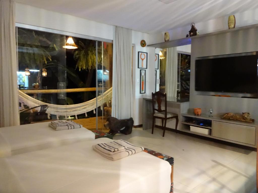 a bedroom with a bed and a large window at Bangalô no alto da colina no Villas do Pratagy - Maceió in Maceió