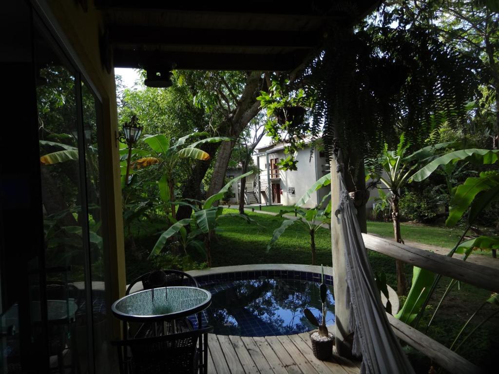 a patio with a hammock and a pool at Bangalô no alto da colina no Villas do Pratagy - Maceió in Maceió