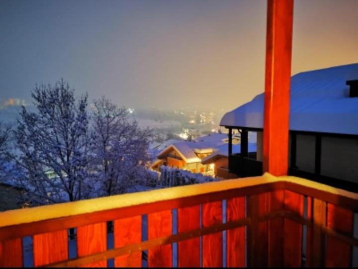 een balkon met uitzicht op een huis met sneeuw bij APARTHOTEL STREMBO in Strembo