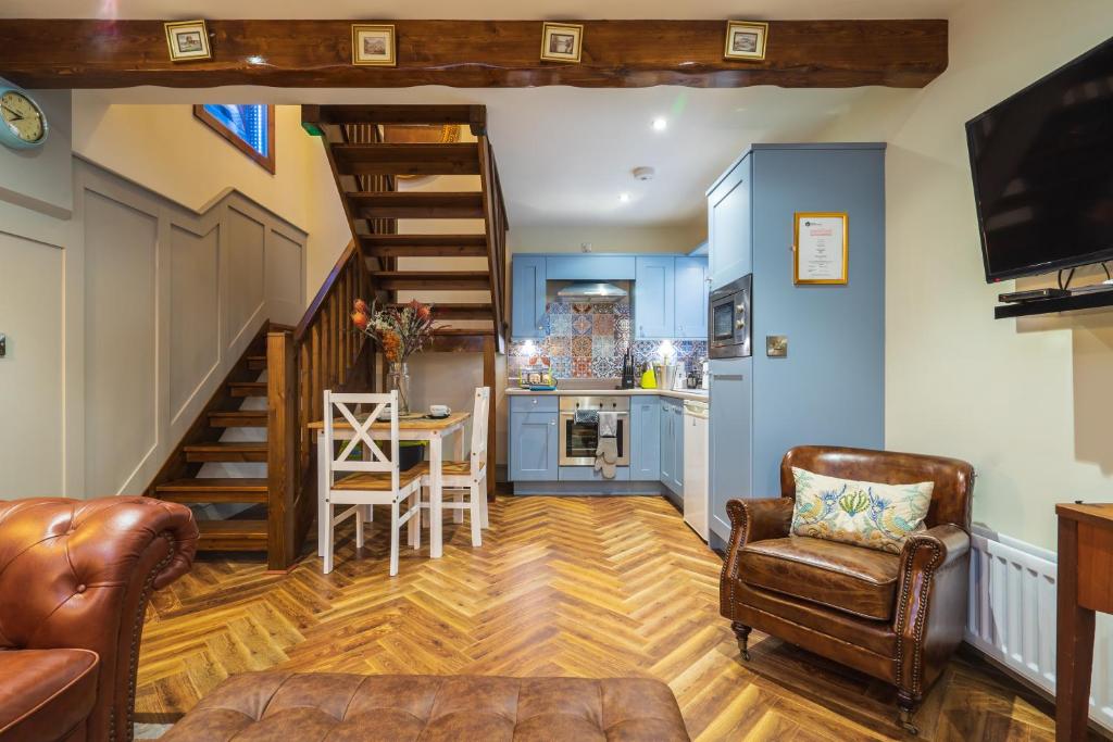 a living room with a staircase and a kitchen at Sorley Boys Snug in Derry Londonderry