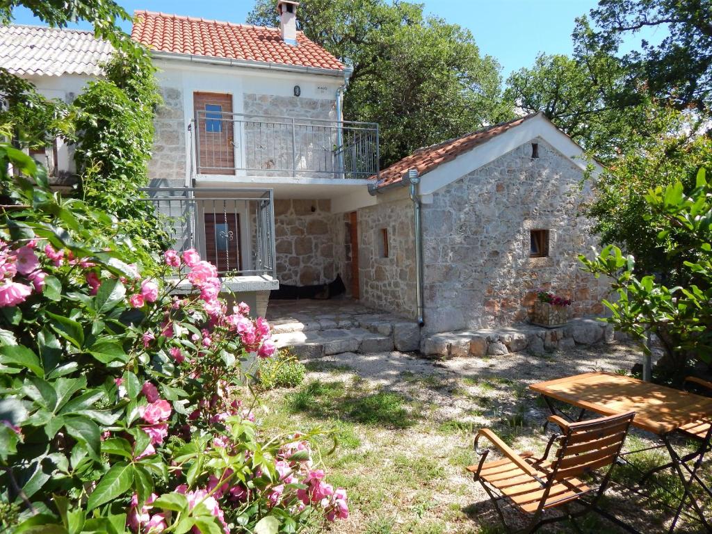 una casa in pietra con una panchina nel cortile di House Paklenica stone beauty a Starigrad-Paklenica (Ortopula)