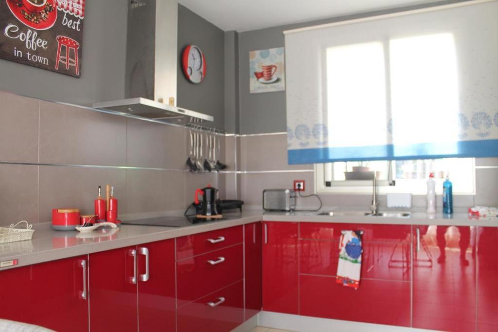 a kitchen with red cabinets and a window at Casa Alisios in Telde