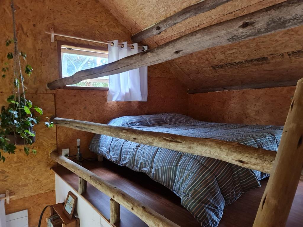 1 dormitorio con 2 literas en una cabaña de madera en El Ranchito Blanco, en La Pedrera