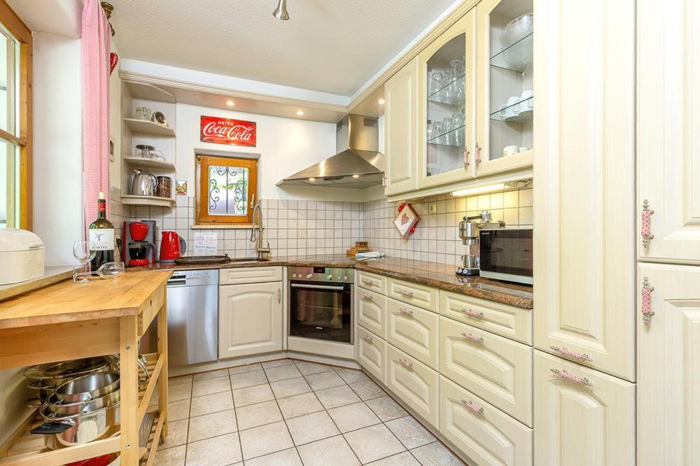 a large kitchen with white cabinets and appliances at Ferienhaus Thimlefi in Reit im Winkl
